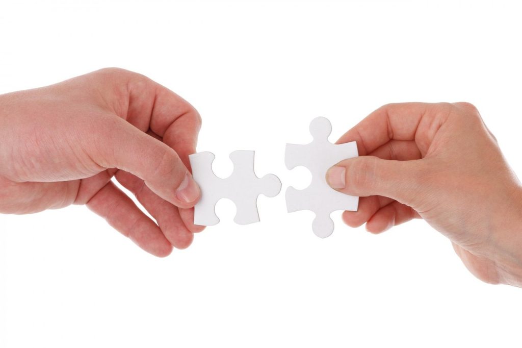 Manos de una persona sujetando dos piezas de un puzzle.